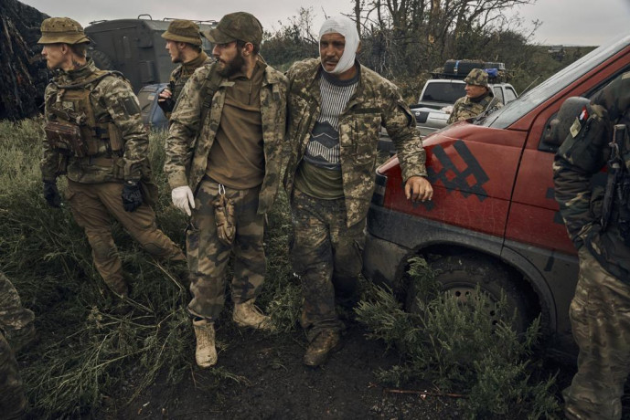 A Ukrainian soldier helps a wounded fellow soldier on the road in the freed territory in the Kharkiv region, Ukraine, Monday, Sept. 12, 2022. AP/RSS Photo