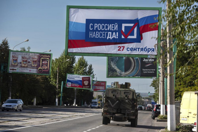 FILE - A military vehicle drives along a street with a billboard that reads: "With Russia forever, September 27", prior to a referendum in Luhansk, Luhansk People's Republic controlled by Russia-backed separatists, eastern Ukraine, Thursday, Sept. 22, 2022.  AP/RSS Photo