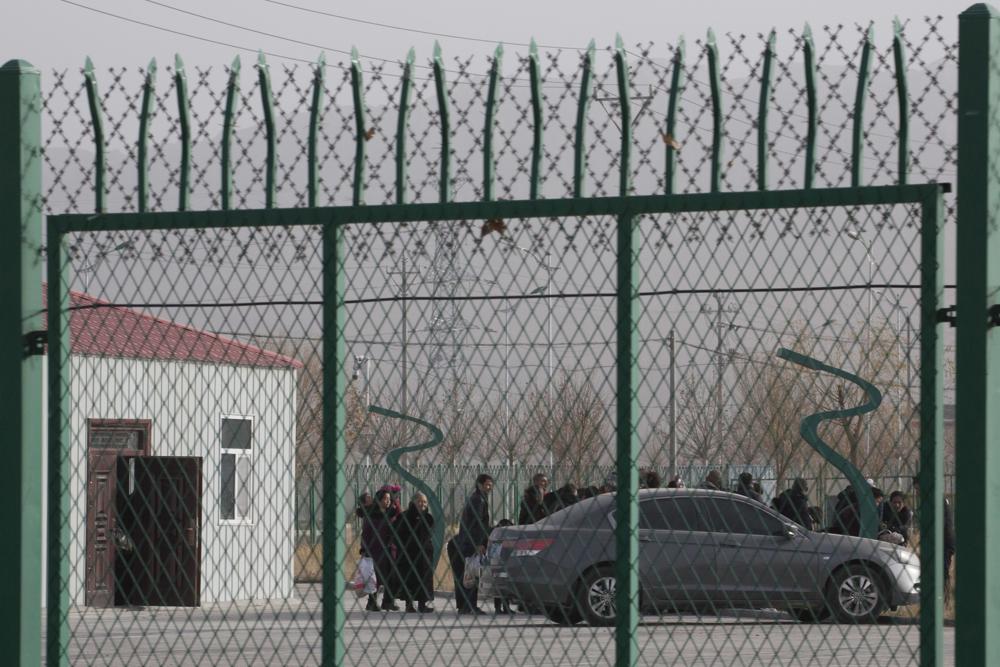 FILE - Residents line up inside the Artux City Vocational Skills Education Training Service Center which has previously been revealed by leaked documents to be a forced indoctrination camp at the Kunshan Industrial Park in Artux in western China's Xinjian